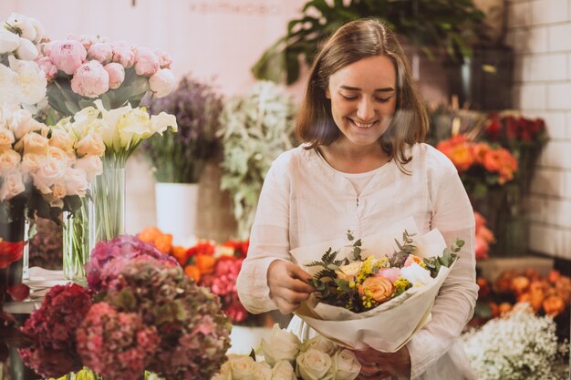 Fiorista donna nel suo negozio floreale prendersi cura dei fiori