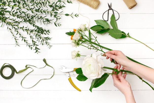 Fiorista femminile che fa bello mazzo al negozio di fiore