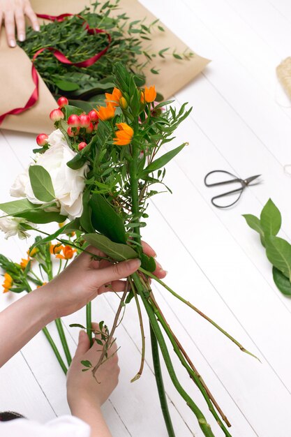 Fiorista femminile che fa bello mazzo al negozio di fiore