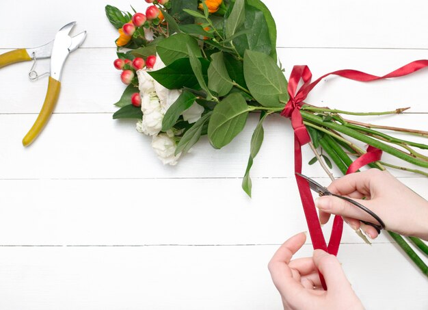 Fiorista femminile che fa bello mazzo al negozio di fiore