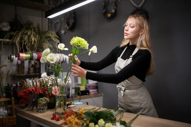 Fiorista femminile che fa una bella composizione di fiori