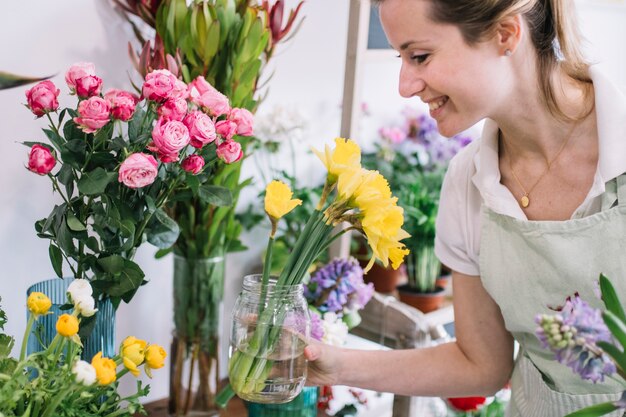 Fiorista sorridente che ispeziona i fiori