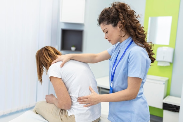 Fisioterapista che esegue un trattamento curativo sulla schiena della donna Sindrome dell'ufficio del massaggiatore medico per il trattamento del paziente con dolore alla schiena