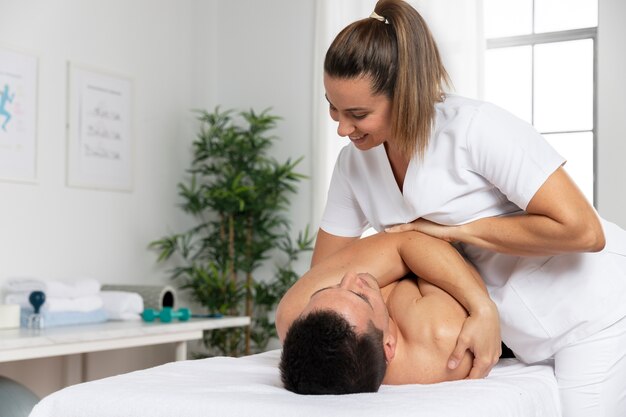 Fisioterapista che massaggia il paziente in ufficio