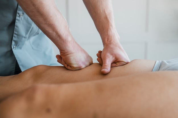 Fisioterapista maschio su una sessione di massaggio con paziente femminile