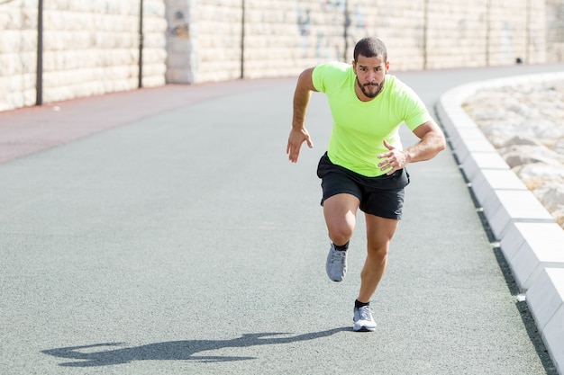 Fisso forte uomo sportivo correre veloce sulla strada