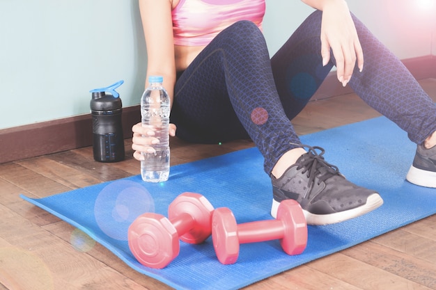 Fitness donna azienda bottiglia di acqua dopo allenamento, concetto di stile di vita sano