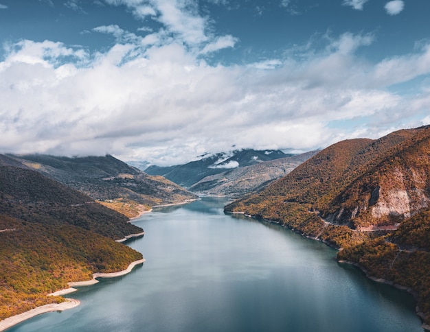 Fiume che attraversa le colline sotto il cielo nuvoloso mozzafiato