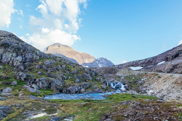 Fiume che scorre attraverso il paesaggio di montagna di roccia in estate