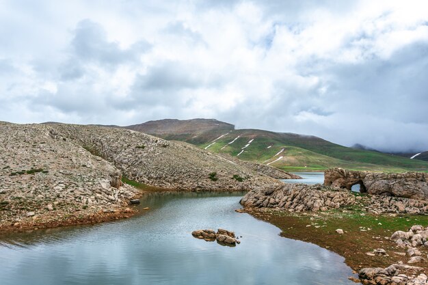 Fiume che scorre attraverso le colline rocciose. giornata nuvolosa