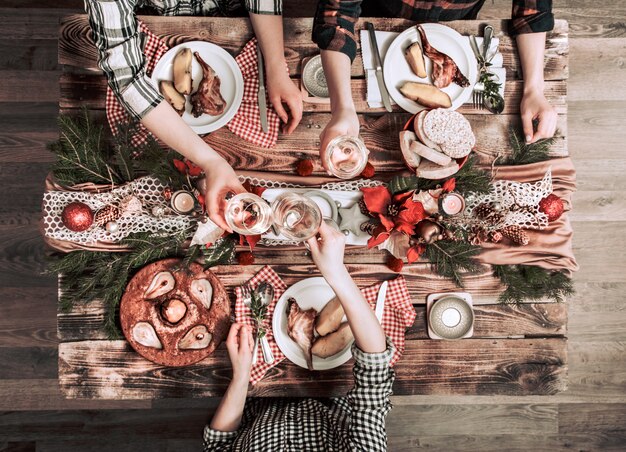 Flat-lay di amici mani mangiare e bere insieme. Vista dall'alto di persone che hanno festa, raccolta, celebrando insieme al tavolo rustico in legno