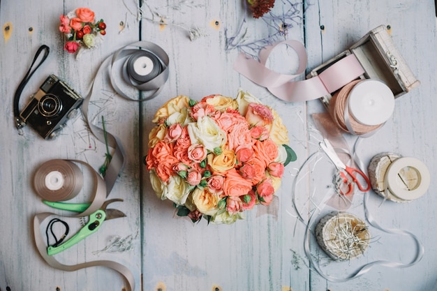 Flatlay di bouquet di nozze arancione e nastri sul tavolo da lavoro