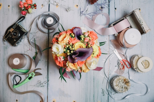 Flatlay di bouquet di nozze, nastri e fotocamera