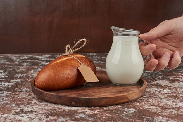 Focacce di pane su marmo con un barattolo di latte.