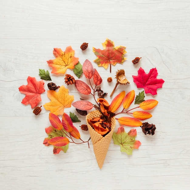 Foglie di autunno di vista superiore con fondo di legno