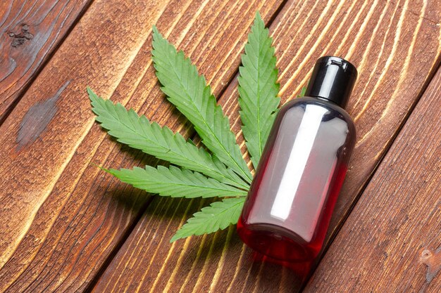 Foglie di cannabis e olio su fondo in legno