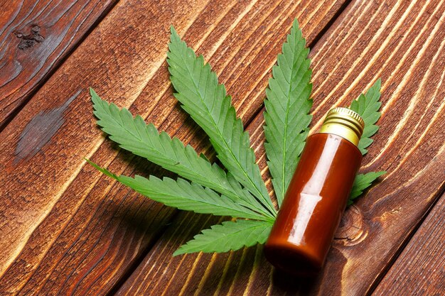 Foglie di cannabis e olio su fondo in legno