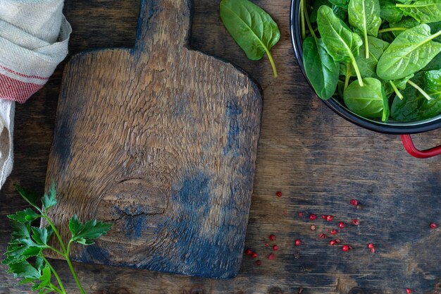 Foglie di spinaci fresche in una ciotola su un tavolo di legno rustico