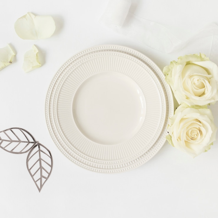 Foto gratuito foglie tagliate; rose e piatto di ceramica; nastro su sfondo bianco