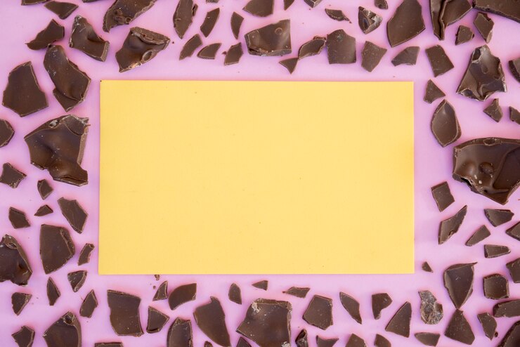 Foto gratuito foglio di carta bianca con cioccolato incrinato sul tavolo