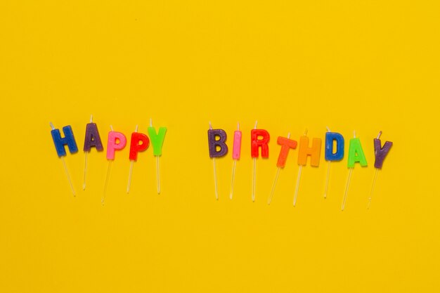 Fondo amarillo con confeti y las Letras &quot;happy birthday&quot;