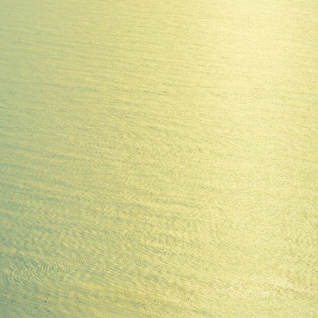 Fondo d&#39;annata dell&#39;acqua di mare con luce del sunflare dal sole