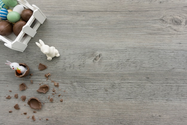 Fondo in legno con conigli e cioccolato per il giorno di Pasqua