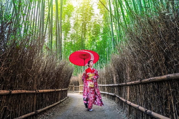 Foresta di bamboo. Donna asiatica che indossa il kimono tradizionale giapponese alla foresta di bambù a Kyoto, Giappone.