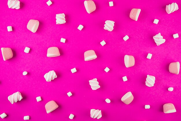 Forma diversa di marshmallow su sfondo rosa