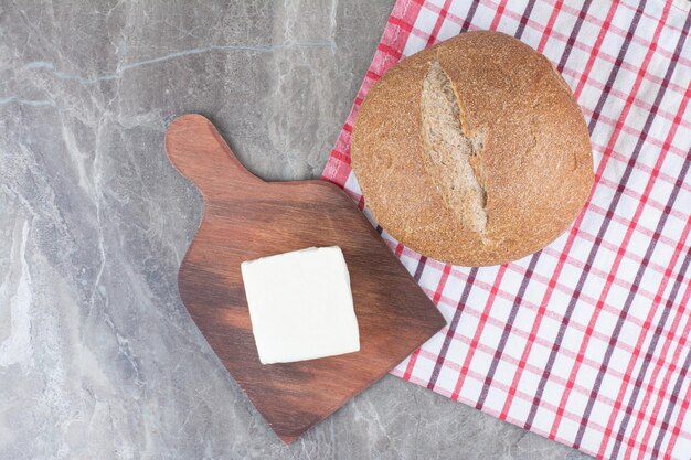 Formaggio bianco fresco con pane sulla tovaglia. Foto di alta qualità