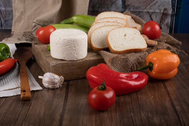 Formaggio e verdure su una tavola di legno