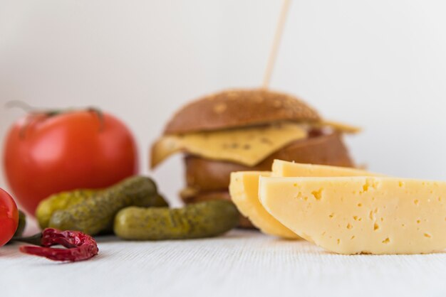 Formaggio fresco vicino a pomodori, cetrioli e sandwich