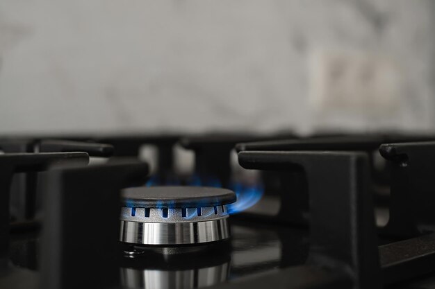 Fornello da cucina moderno, brucia gas naturale con una fiamma blu. Consumo di gas domestico. Primo piano, fuoco selettivo
