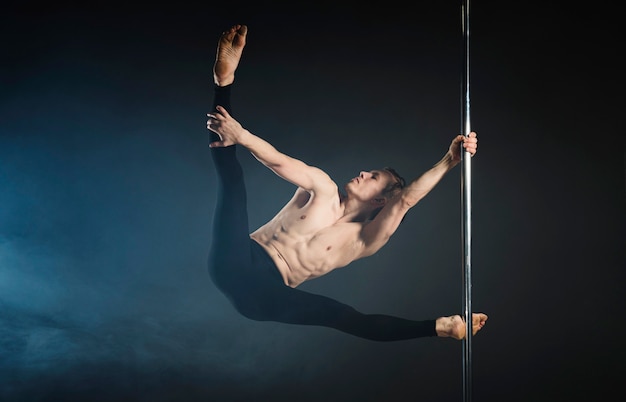 Forte giovane che esegue una pole dance