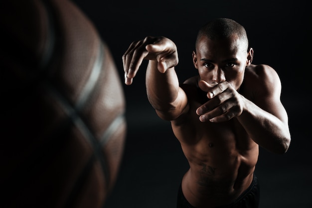 Foto del primo piano della palla di lancio del giocatore di pallacanestro afroamericano,