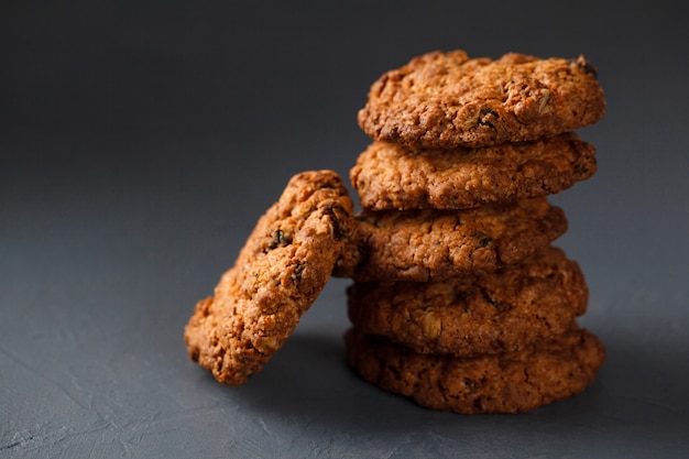 Foto del primo piano della pila dei biscotti di farina d'avena su superficie grigia