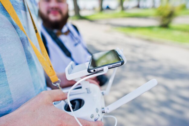 Foto del primo piano delle mani maschili che tengono il telecomando di un drone