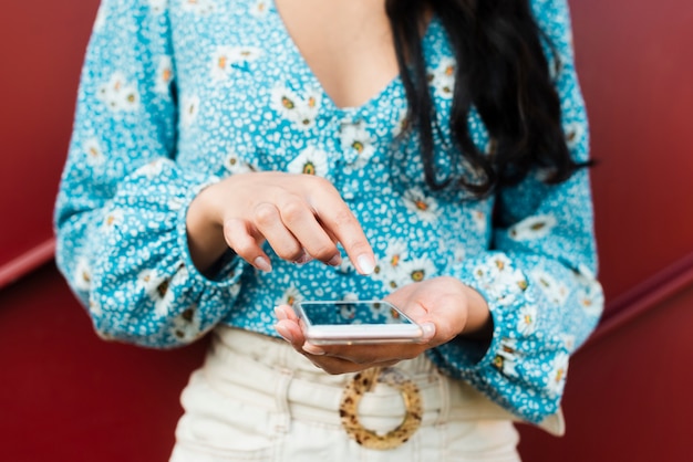 Foto della donna che usando e che indica al suo telefono