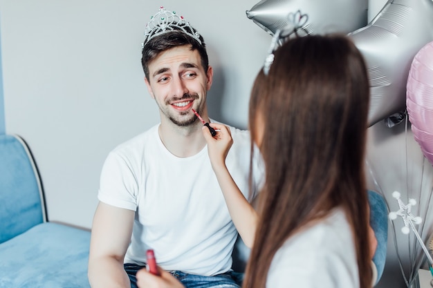 Foto della figlia bruna che fa il trucco con il pennello al padre