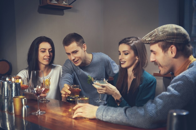 Foto di amici allegri al bar o al pub che comunicano tra loro