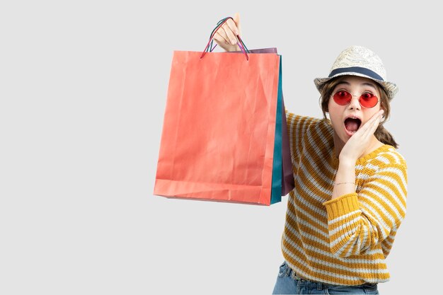 Foto di giovane donna castana in occhiali da sole che tengono le borse della spesa. Foto di alta qualità
