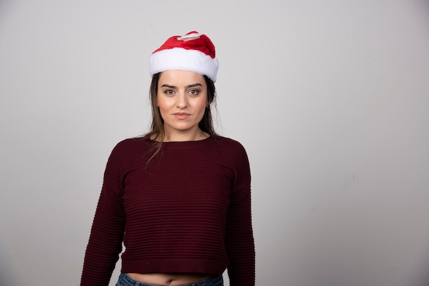 Foto di giovane donna con cappello di Natale guardando la telecamera.