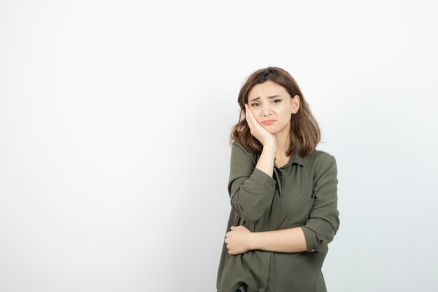 Foto di giovane ragazza che ha mal di denti sul muro bianco. Foto di alta qualità