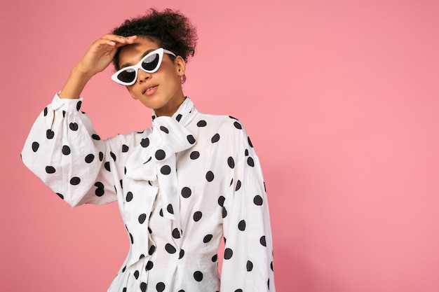 Foto di studio di donna nera africana in abito elegante e occhiali da sole bianchi