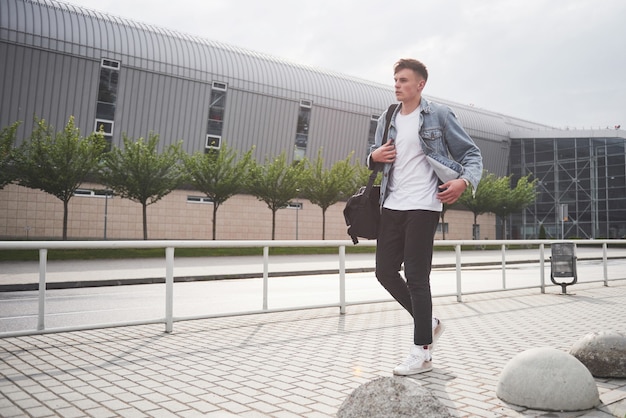 Foto di un giovane uomo prima di un emozionante viaggio in aeroporto.