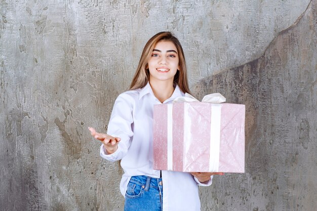 Foto di una bella modella con i capelli lunghi che tiene in mano un grande regalo