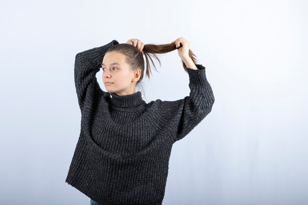 Foto di una bella ragazza che fissa i suoi capelli su gray.