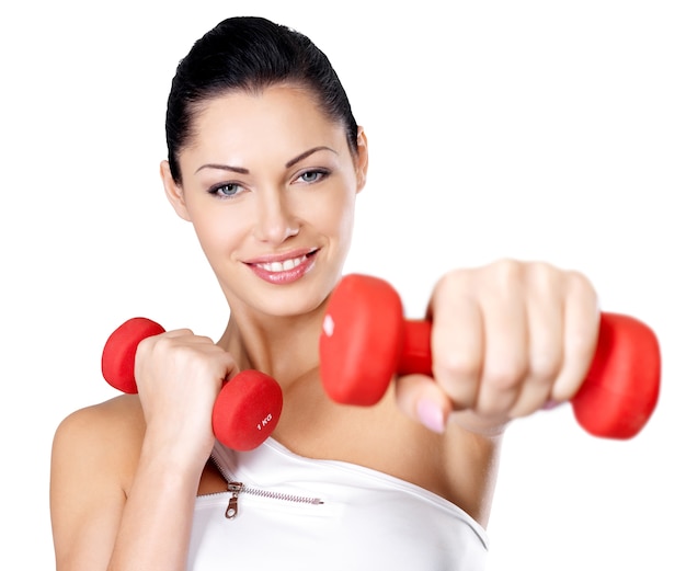 Foto di una giovane donna sana di addestramento con i dumbbells. Concetto di stile di vita sano.