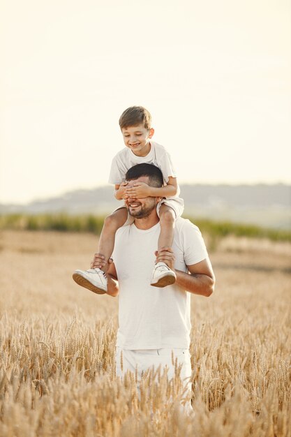 Foto di una giovane famiglia al campo di girasoli in una giornata di sole.