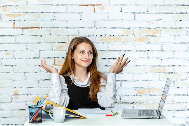 Foto di una ragazza della scuola che tiene le mani in alto e sorride